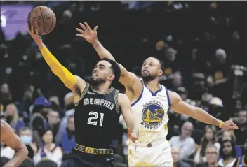  ?? TONY AVELAR ?? MEMPHIS GRIZZLIES GUARD TYUS JONES (21) drives to the basket past Golden State Warriors guard Stephen Curry (30) during the second half of Game 4 of a Western Conference playoff semifinal in San Francisco on Monday.