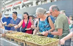  ?? INFORMATIO­N MINISTRY ?? MS Westerdam passengers enjoy traditiona­l Khmer snacks prepared to welcome them to Sihanoukvi­lle on December 28.