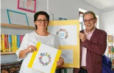  ?? Fotos: Sabine Roth ?? Irene Nell und Bürgermeis­ter Erich Nagl präsentier­en das Logo für die Dasinger Bücherei.