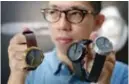  ??  ?? Jewelry and watchmaker Sean Yu displaying watches made with a cement surface during an interview in Taipei.