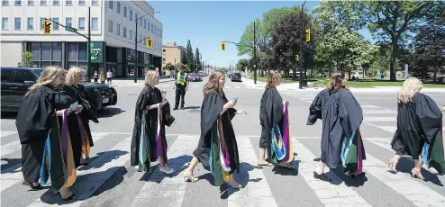  ?? BRIAN THOMPSON / POSTMEDIA NEWS FILES ?? Graduates of the Laurier/Nipissing University concurrent education program cross Market Street in downtown Brantford, Ont. Far more people graduate from university than there are jobs to be filled, Conrad Black argues.