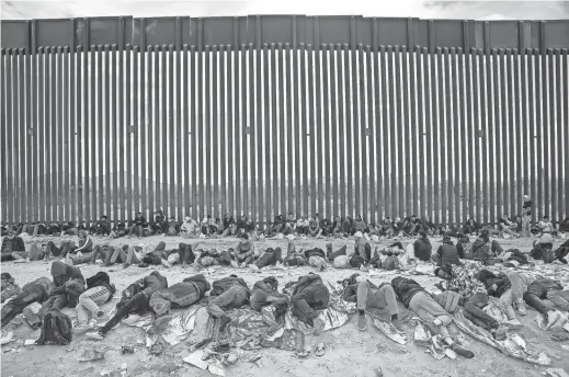  ?? JOEL ANGEL JUAREZ/THE REPUBLIC ?? Migrants and asylum seekers wait to be picked up and processed by U.S. Border Patrol agents in Organ Pipe Cactus National Monument along the U.S.-Mexico border about a mile west of Lukeville on Dec. 4. The Lukeville Port of Entry was closed by officials on Dec. 4 but reopens today.