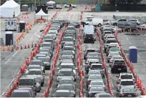  ?? JOE RAEDLE/GETTY IMAGES ?? Drivers wait to be tested for COVID-19 at the Hard Rock Stadium parking lot July 6 in Miami Gardens, Fla.