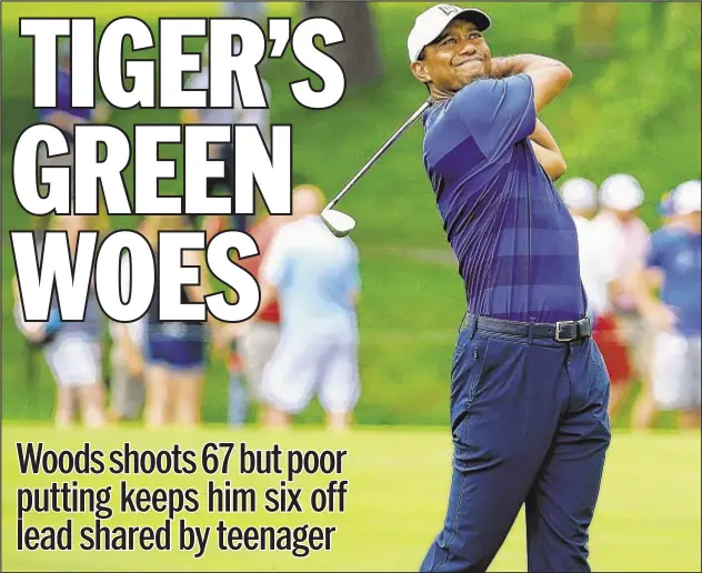  ??  ?? After shooting even on Thursday at the Memorial in Dublin, Ohio, Tiger Woods roared back with a 5-under 67 Friday in the second round, but he missed four putts within seven feet to stunt what could’ve been a memorable round. He trails leaders Kyle...