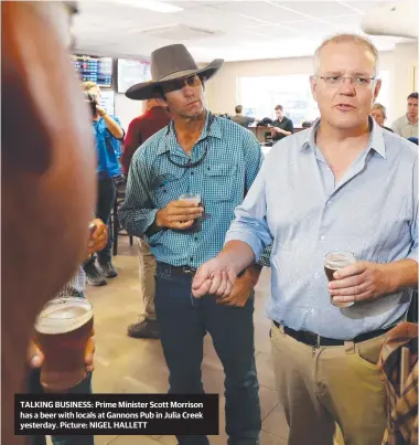  ??  ?? TALKING BUSINESS: Prime Minister Scott Morrison has a beer with locals at Gannons Pub in Julia Creek yesterday. Picture: NIGEL HALLETT
