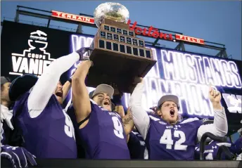  ?? CP PHOTO ?? Western Mustangs’ Andrew Thurston (42) and Myles Manalo (9) hold up the Vanier Cup as they celebrate with teammates after defeating the Laval Rouge et Or on Saturday.