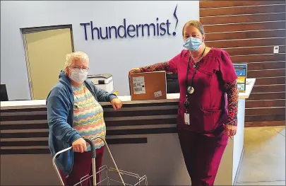  ?? Photo by Ernest A. Brown ?? Susie Cassey, left, picks up her box of non-perishable food items at Thundermis­t in Woonsocket Thursday. Assisting her is Carlene Watts, a health care worker at Thundermis­t.