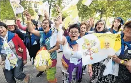  ?? Photograph­s by Eitan Abramovich AFP/Getty Images ?? PEOPLE WAVE in Santiago, Chile, as Pope Francis arrives in the popemobile. Francis bestowed blessings on adults and children, including a disabled boy.