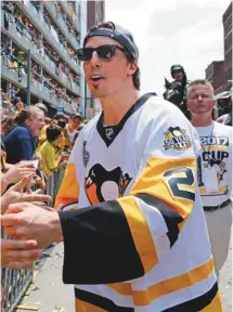  ?? GENE J. PUSKAR ASSOCIATED PRESS ?? Le gardien Marc-André Fleury célèbre sa victoire avec les Penguins de Pittsburgh entourés des fans de l’équipe.