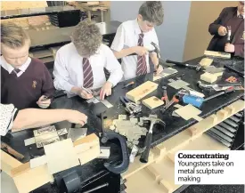  ??  ?? Concentrat­ing Youngsters take on metal sculpture making