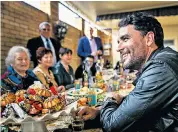  ??  ?? Globetrott­er: Levison Wood at home in London, top, and listening to stories as he meets people in the Caucasus in his latest series, left