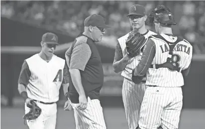  ?? PATRICK BREEN/AZCENTRAL SPORTS ?? Diamondbac­ks pitching coach Mike Butcher visits starting pitcher Anthony Banda on the mound after Banda gave up three runs to the Los Angeles Dodgers in the first inning Thursday night at Chase Field.