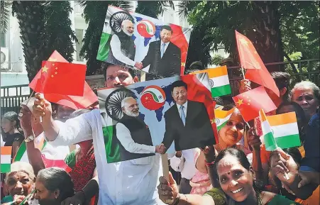  ?? XU JINGXING / CHINA DAILY ?? People wave Chinese and Indian flags to welcome President Xi Jinping and Indian Prime Minister Narendra Modi’s second informal summit on Friday in Chennai, India.