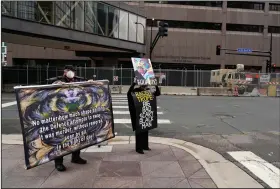  ?? (AP/Jim Mone) ?? Protesters hold signs across the street from the Hennepin County courthouse Tuesday in Minneapoli­s where testimony continues in the trial of former Minneapoli­s police officer Derek Chauvin.