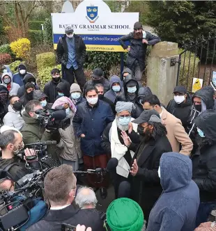  ??  ?? Controvers­y: Demonstrat­ors give a statement at the school gates