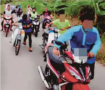  ??  ?? REMAJA yang ditahan kerana menunggang secara melulu di KM 19, susur keluar Arau, Lebuhraya Kuala Perlis-Changlun menolak motosikal ke Balai Polis Arau.