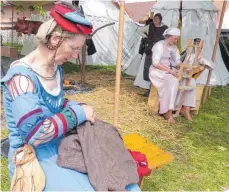  ??  ?? Frauen betätigen sich mit Nadel und Faden und am Webstuhl.