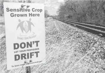  ?? KANSAS STATE DEPARTMENT OF AGRICULTUR­E ?? A sign put up by the Kansas State Department of Agricultur­e alerts nearby farmers to crops sensitive to herbicide drift. Below: Drift damage from the herbicide dicamba to a 70-acre field of soybeans near Fairmount, Ind.