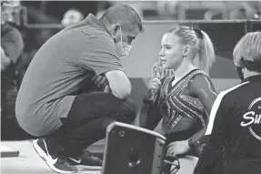  ?? TONY GUTIERREZ/AP ?? Coach Brian Carey, left, talks with his daughter, Jade Carey, before her floor exercise routine Friday.