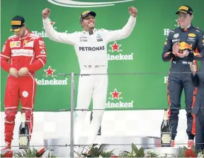  ?? AP ?? Mercedes driver Lewis Hamilton of Britain (centre) leaps as he arrives at the podium with Ferrari driver Sebastian Vettel of Germany (left) and Red Bull driver Max Verstappen of the Netherland­s after winning the Chinese Formula One Grand Prix at the...