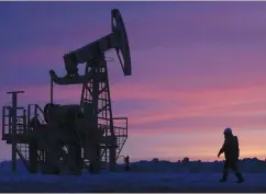  ?? (Sergei Karpukhin/Reuters) ?? A WORKER walks past a pump jack on an oil field in Bashkortos­tan, Russia, January 28, 2015.