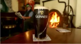  ?? Paul Faith/AFP via Getty Images ?? In Ireland, kids leave Santa a pint of Guinness stout to wash down the cookies on Christmas Eve.