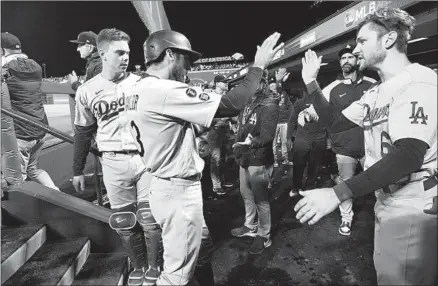  ?? Wally Skalij Los Angeles Times ?? THE DODGERS’ Chris Taylor, left, celebrates with Trea Turner after scoring on a two-run double by AJ Pollock during the sixth inning of Game 2 against the San Francisco Giants. Pollock’s two-run double gave the Dodgers a five-run lead en route to a 9-2 win.