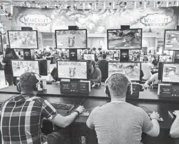  ?? GETTY IMAGES ?? Visitors try out the massively multiplaye­r online role-playing game 'World Of Warcraft' at the Blizzard Entertainm­ent stand at the Gamescom 2016 gaming trade fair on Aug. 17.