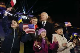  ?? EVAN VUCCI — THE ASSOCIATED PRESS ?? President Joe Biden stands with children after delivering a speech marking the one-year anniversar­y of the Russian invasion of Ukraine on Tuesday during a visit to the Royal Castle Gardens in Warsaw.