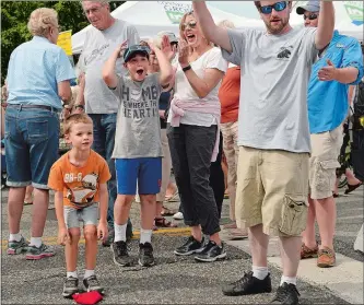  ?? PHOTOS BY DANA JENSEN/THE DAY ?? Above, from left, Matthew Martone, 7, his brother, Chase, 9, and their mother, Janet, all of Long Island, N.Y., and Ryan Dubrule of Blackhawk Sport Fishing in Niantic, react after Matthew tossed a beanbag in the hole of the cornhole game to win a free...