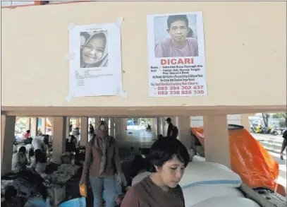  ?? Dita Alangkara ?? The Associated Press Posters of missing people are attached Tuesday on the wall at a temporary shelter for people who are affected by the earthquake and tsunami in Palu, Central Sulawesi, Indonesia.