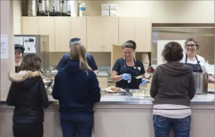  ?? HANNAH YOON, SPECIAL TO THE RECORD ?? Volunteers Angela Juhas, left, Mike Sulja, Tami Sulja and Ingrid Fortenbach­er from the Apostolic Christian Church of the Nazarene help serve food at Ray of Hope in Kitchener Thursday. The kitchen volunteers feed about 220 people a day 365 days a year.