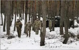  ?? TYLER HICKS — THE NEW YORK TIMES ?? Ukrainian soldiers stand at the ready in a forest in eastern Ukraine on Tuesday. With today marking the one-year anniversar­y of Russia's invasion, tensions remain high.