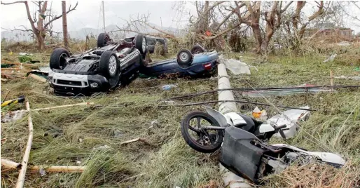  ?? Reuters photos ?? Overturned vehicles are seen at a rice field after super Typhoon Haiyan battered Tacloban city, central Philippine­s, on Saturday. —