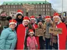  ?? Bryant/The Guardian ?? Rikke LaCour, holding a ‘king of the people’ sign, with Karin Beukel and other friends and family outside Christians­borg Palace in Copenhagen. Photograph: Miranda
