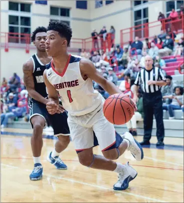  ??  ?? Heritage’s Tylon Gaines drives past Ridgeland’s Markeion Jones on his way to the hoop during a game this past Friday in Ringgold. The Generals, who lost to the Panthers in Rossville last Tuesday, got revenge with a 76-62 win. (Photo by Bambara...