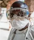  ??  ?? Dieser Mann untersucht im afrikani schen Land Kongo Patienten und kon trolliert, ob sie an Ebola erkrankt sind. Mit Mundschutz und Brille versucht er sich vor dem Virus zu schützen.