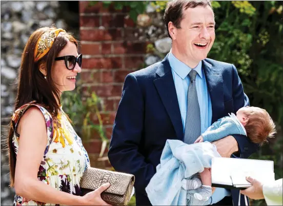  ??  ?? LITTLE BOY BLUE: The former Chancellor George Osborne, with fiancee Thea Rogers, cradles their son Beau at the wedding in Hampshire yesterday