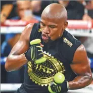  ?? JOE CAMPOREALE / USA TODAY SPORTS ?? Floyd Mayweather throws punches with weights in his hands in preparatio­n for his Aug 26 bout with Conor McGregor at T-Mobile Arena in Las Vegas.