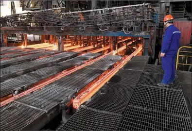  ?? AP file photo ?? A steelworke­r at Xiwang Special Steel in Zouping County in eastern China’s Shandong province oversees production last week. Chinese steel mills account for half the world’s steel production.