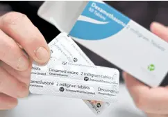  ?? PROCEED WITH CAUTION A pharmacist holds a box of dexamethas­one tablets at a chemist’s shop in London in this photo taken on June 16. —AFP ??