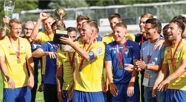  ?? FOTOS: SASCHA FROMM (2), TINO ZIPPEL ?? Jenas Kapitän René Eckardt hebt den schweren Pokal in die Höhe und feiert mit seinen Mannschaft­skollegen den elften Pokalsieg – Thüringer Rekord.