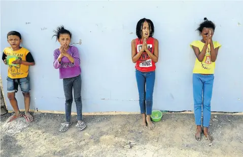  ?? Pictures: Esa Alexander ?? Children start with a prayer before they are fed by the Prince Albert Community Trust, which gives them two meals a day during the lockdown.