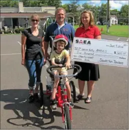  ?? Submitted photo ?? WISH COME TRUE ... Souderton Area School District teachers and Indian Valley AMBUCS helped fulfill a wish for West Broad Elementary third-grader Joshua Holt by presenting him with a therapeuti­c tricycle. Joshua received a therapeuti­c tricycle from...