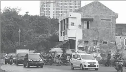  ?? DIKA KAWENGIAN/ JAWA POS ?? TERGANJAL: Frontage road A. Yani menyempit di bundaran Dolog gara-gara ada bangunan yang belum dibongkar. Pembebasan bangunan kini masuk ranah hukum.