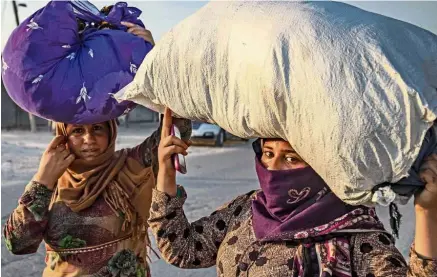  ??  ?? No respite: Civilians carrying their belongings as they flee amid Turkish bombardmen­t on Syria’s northeaste­rn town of Ras al-Ain in the Hasakeh province along the Turkish border.