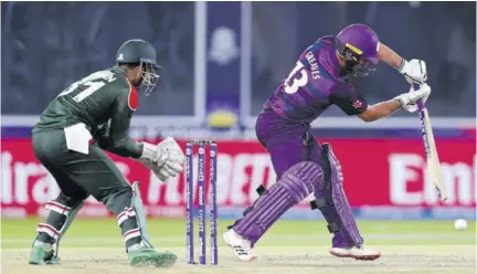  ?? (photos: afp) ?? Scotland’s Chris Greaves (right) plays a shot as Bangladesh’s wicketkeep­er Nurul Hasan watches during the ICC men’s Twenty20 World Cup cricket match between Bangladesh and Scotland at the Oman Cricket Academy Ground in Muscat yesterday.