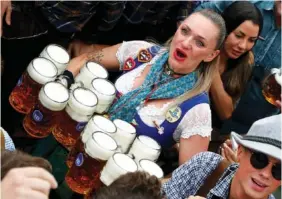  ?? AP PHOTO/MATTHIAS SCHRADER, FILE ?? A waitress holds twelve glasses of beer in 2019 during the opening of the 186th ‘Oktoberfes­t’ beer festival in Munich, Germany.