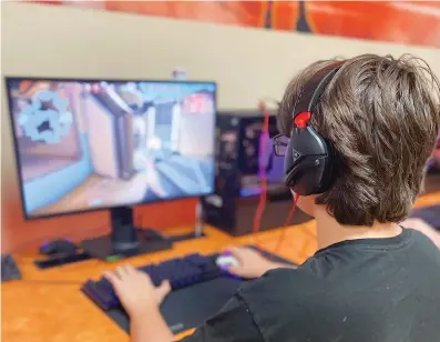  ?? Staff photo by Andrew Bell ?? ■ Freshman Bradley Ervin warms up by playing Valorant in the Texas High School Esports Arena.