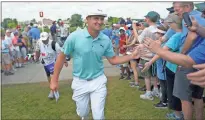  ?? Ap-jerry Holt ?? Bryson Dechambeau greets fans as he leaves the ninth hole during the second round of the 3M Open in Blaine, Minn., on Friday.